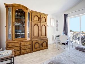 a large wooden cabinet in a room with a table at Apartment Les Villageoises-2 by Interhome in Le Barcarès +19 photos