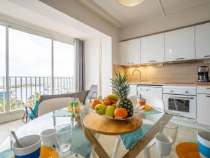 a kitchen with a table with a bowl of fruit on it at Apartment La Balancine by Interhome in Hyères +27 photos