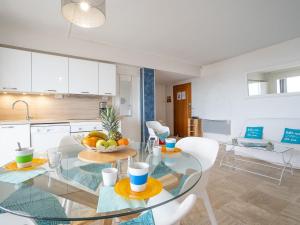 a kitchen and dining room with a glass table and chairs at Apartment La Balancine by Interhome in Hyères