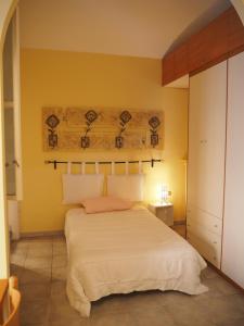 a bedroom with a white bed and a yellow wall at Palazzina al Lingotto in Turin