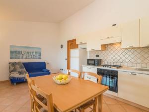 eine Küche mit einem Tisch mit einer Obstschale darauf in der Unterkunft Holiday Home Corbezzolo by Interhome in Costa Paradiso