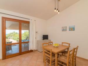 ein Esszimmer mit Tisch und Stühlen und einem Fernseher in der Unterkunft Holiday Home Corbezzolo by Interhome in Costa Paradiso