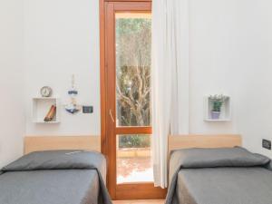 een kamer met 2 bedden en een deur met een raam bij Holiday Home Erica by Interhome in Costa Paradiso
