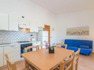 een keuken en eetkamer met een tafel en een blauwe bank bij Holiday Home Erica by Interhome in Costa Paradiso