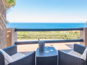 a table and chairs with a view of the ocean at Holiday Home Li Cossi by Interhome in Costa Paradiso