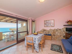 a living room with a table and a view of the ocean at Holiday Home Li Cossi by Interhome in Costa Paradiso
