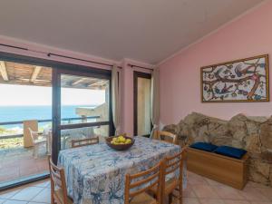 a dining room with a table and a view of the ocean at Holiday Home Li Cossi by Interhome in Costa Paradiso