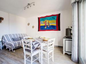 ein Esszimmer mit Tisch und Stühlen und einem Gemälde in der Unterkunft Apartment Les Villageoises-3 by Interhome in Le Barcarès