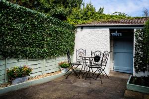a patio with a table and chairs next to a building at Laurel Cottage in Lincolnshire