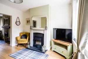 a living room with a tv and a fireplace at Laurel Cottage in Lincolnshire