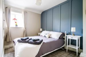 a bedroom with a large bed with blue walls at Laurel Cottage in Lincolnshire