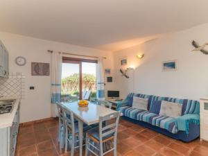 a living room with a blue couch and a table at Apartment Capo Testa by Interhome in Capo Testa