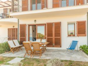 un patio con mesa de madera y sillas en Apartment Capo Testa by Interhome en Capo Testa
