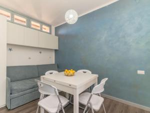 uma sala de jantar com uma mesa branca e cadeiras em Apartment Baia blu by Interhome em Santa Teresa Gallura