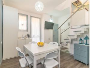 uma cozinha e sala de jantar com uma mesa branca e cadeiras em Apartment Baia blu by Interhome em Santa Teresa Gallura