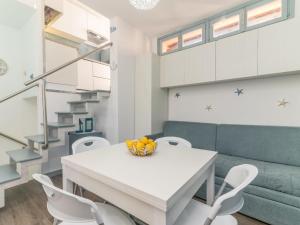 uma cozinha e sala de jantar com uma mesa branca e cadeiras em Apartment Baia blu by Interhome em Santa Teresa Gallura