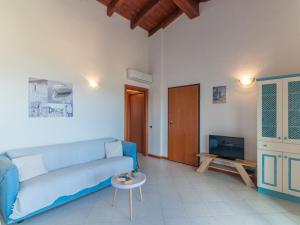 sala de estar con sofá azul y TV en Apartment I Mirti 28 by Interhome, en Porto Pozzo
