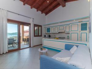 sala de estar con sofá azul y cocina en Apartment I Mirti 28 by Interhome, en Porto Pozzo