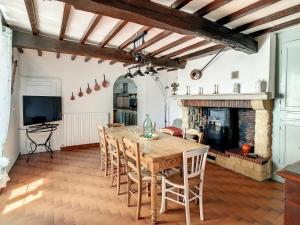 a dining room with a table and chairs and a fireplace at Ferme Gascone proche Marciac in Bars