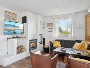 ein Wohnzimmer mit einem Sofa und einem Kamin in der Unterkunft Holiday Home Velika - 25m to the inlet in Sealand by Interhome in Grevinge