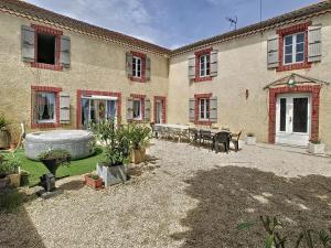 a courtyard of a building with a fountain and tables at Ferme Gascone proche Marciac in Bars