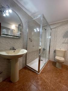 y baño con ducha, lavabo y aseo. en Luarca Zabala Hotel en Luarca