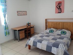 a bedroom with a bed and a desk and a table at ZEN SOUFRIERE in Saint-Claude