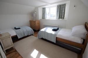 1 dormitorio con 2 camas y ventana en Greystone Cottage - Sea views, short stroll to a beautiful sandy beach, en Brook
