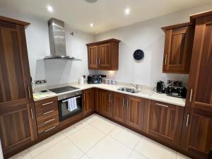 a kitchen with wooden cabinets and a stove top oven at 2 Castle Hume Court Holiday House in Enniskillen