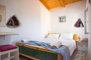 a bedroom with a bed with a blue blanket on it at Two little houses with panorama view in Kýthira