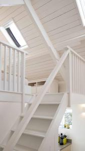 eine weiße Treppe in einem Haus mit einem Oberlicht in der Unterkunft Gemütliches Cottage mit Meerblick in Ballydehob