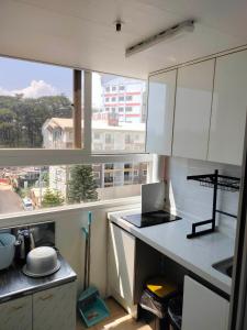 a kitchen with white cabinets and a large window at Zenmist Properties- 2 Bedroom Deluxe in Baguio
