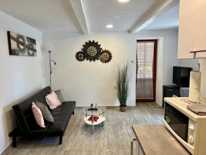 sala de estar con sofá negro y mesa en Apartment Orkić, en Rovinj