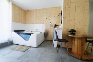 a bathroom with a tub and a table and a chair at Le Cocon de Lily in Saint-Savin-de-Blay