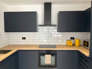 a kitchen with black cabinets and a stove top oven at IR Benfleet south in South Benfleet