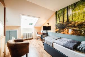 1 dormitorio con cama, silla y escritorio en Landhotel Alte Aue, en Altenau