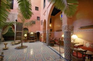 a lobby with a palm tree in a building at Dar Anebar in Fès