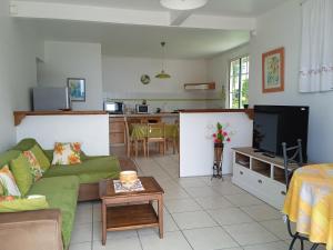 a living room with a couch and a tv at ZEN SOUFRIERE in Saint-Claude