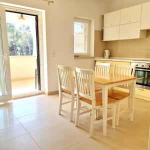 a kitchen with a wooden table and chairs at Apartmani Val in Pula