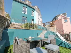 a balcony with a table and chairs in front of a building at 2 North Furzeham Road in Brixham