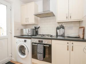 a white kitchen with a washer and dryer in it at 2 North Furzeham Road in Brixham