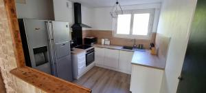 a kitchen with a refrigerator and a sink at Logement refait à neuf - Clim & Parking privé in Montpellier +4 photos