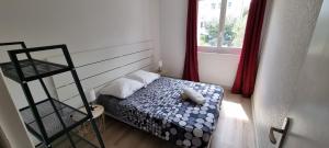 a small bedroom with a bed and a window at Logement refait à neuf - Clim & Parking privé in Montpellier