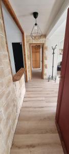 a hallway with a stone wall and a flat screen tv at Logement refait à neuf - Clim & Parking privé in Montpellier