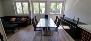 a dining room with a table and a couch at Logement refait à neuf - Clim & Parking privé in Montpellier