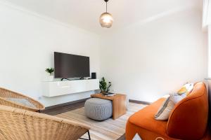 a living room with a tv and a couch at Cascais Duplex Apartment in Cascais