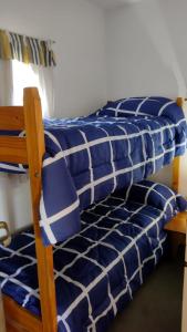 ピナマールにあるDepartamento en Pinamar Centroの二段ベッド2組(青と白のシーツ付)が備わる客室です。 +16枚の写真