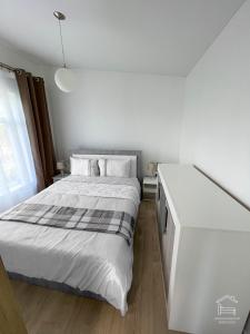 a bedroom with a white bed and a white dresser at Apartamentai Biržuose, Cozy Modern Bungalows in Biržai
