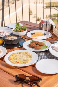 a table with plates of food and glasses on it at Wadi Sabarah Lodge in Marsa Alam City