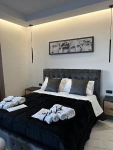 a bedroom with a black bed with towels on it at DIADEMA Luxury Suite in Nardò +10 photos